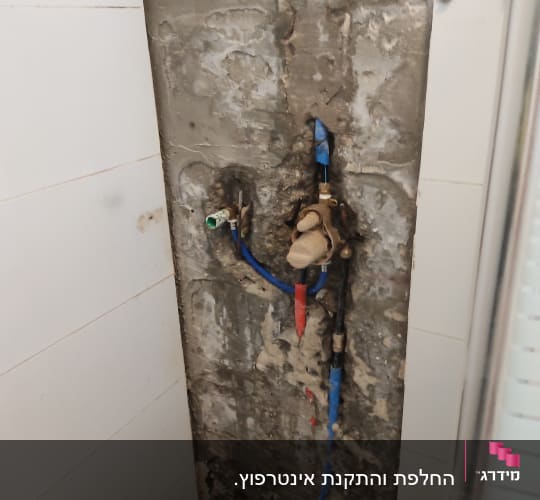 צנרת מים חשופה בקיר עם ברזים